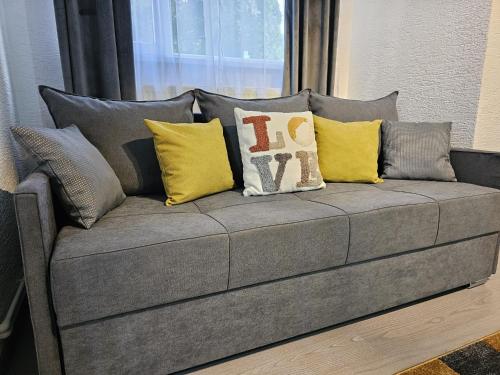 a couch with many pillows on it in a room at Mona Central Apartment in Hunedoara