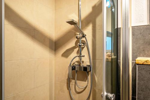 une douche dans une salle de bain avec une pomme de douche dans l'établissement Strandnahes Ferienhaus, à Dierhagen