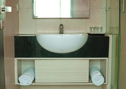 a bathroom with a sink and a counter with towels at World Hotel Jakarta - Bandengan in Jakarta
