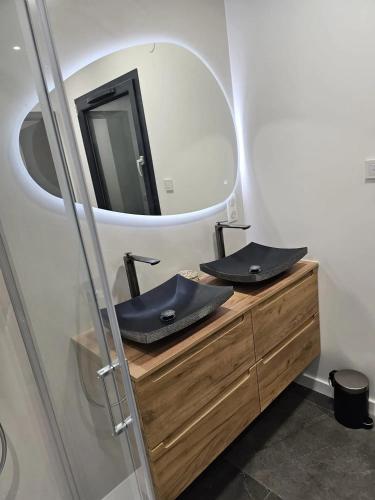 a bathroom with two sinks and a mirror at Villa de 4 chambres avec piscine privee sauna et jardin clos a Riom in Riom