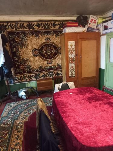 a bedroom with a red bed and a rug at Ismayilli Halal Family Guest House, Ailəvi Bag Evi, Vacation House in İsmayıllı