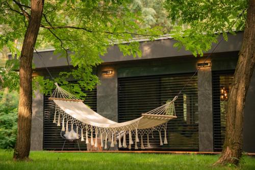 a hammock hanging from a tree in front of a house at Forestlux Vendégház in Zebegény