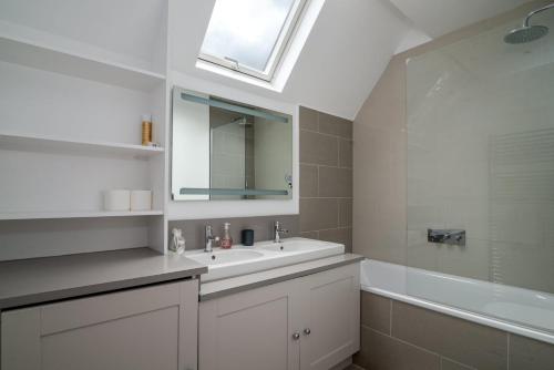 a bathroom with a sink and a mirror and a tub at GuestReady - Chic in the heart of Kensington in London