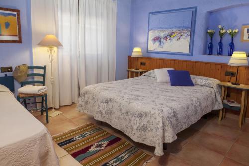 a bedroom with a bed and a table and chairs at Casa Rural Can Coll in Garriguella