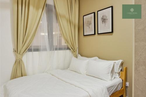 a bedroom with a bed with white pillows and a window at Mosaic Southkey Johor Bahru in Johor Bahru