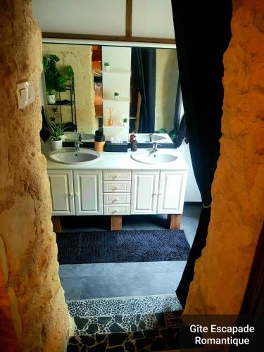 a bathroom with two sinks and a large mirror at Escapade Romantique in Les Roches-lʼÉvêque