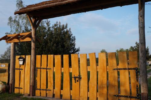 een houten hek naast een houten constructie bij Drewniany Zakątek z sauną i jacuzzi in Jadów