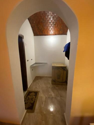 ein Torbogen, der in ein Zimmer mit einem Tisch führt in der Unterkunft Oasis inn House in Mandīshah