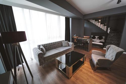 a living room with a couch and a chair at ENNA SUIT HOTEL in Nilüfer