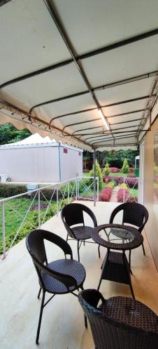 a patio with chairs and a table on a deck at La serene nandihills in Nandi