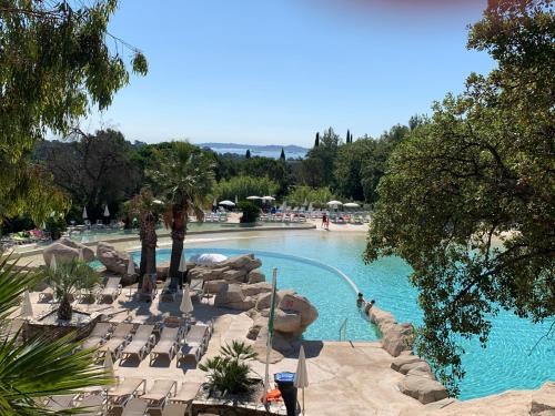 - une grande piscine avec des chaises et des personnes dans l'établissement Appartement région de St-Tropez, à Grimaud