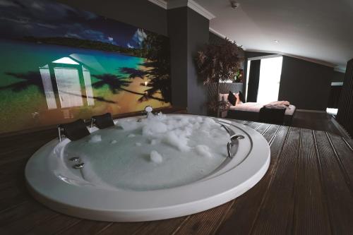 a bathroom with a bath tub with clouds in it at ENNA SUIT HOTEL in Nilüfer