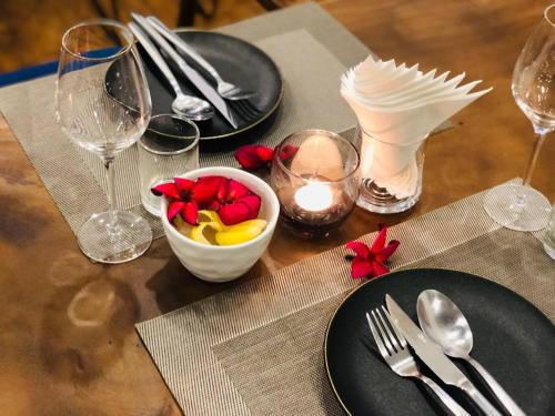 a table with plates and glasses and a bowl of fruit at Suite Home Boutique Hotel in Phnom Penh