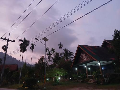 a gas station at night with palm trees at Bamboo House in Khao Sok National Park
