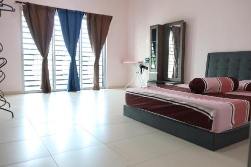 - une chambre avec un lit dans une pièce dotée de fenêtres dans l'établissement JOY SITIAWAN HOMESTAY, à Sitiawan