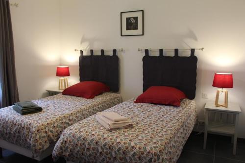 a bedroom with two beds with red pillows and two lamps at Le gîte du Haut-Breuil proche de Beauval châteaux de la Loire in Vicq-sur-Nahon