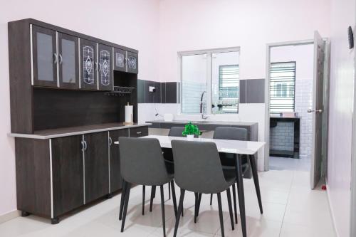 a kitchen with a table and chairs in it at JOY SITIAWAN HOMESTAY in Sitiawan