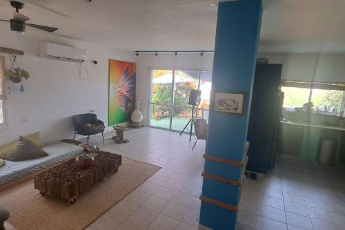 una sala de estar con un poste azul en una habitación en Beach House, en Ashdod