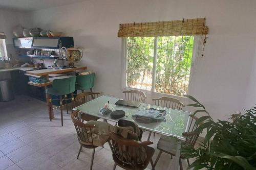 une cuisine avec une table et des chaises ainsi qu'une fenêtre dans l'établissement Beach House, à Ashdod