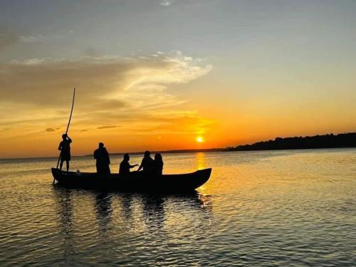 a group of people in a boat on the water at sunset at Bell Farms and Resorts in Munroe Island