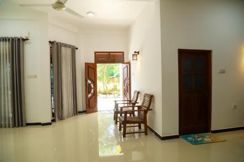 Habitación con sillas, mesa y puerta en Secret Mirage, en Mirissa