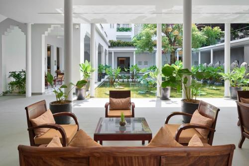 a lobby with chairs and a table and plants at Plantation Urban Resort & Spa in Phnom Penh