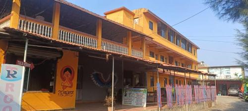 een geel gebouw met een bord ervoor bij Tulsi Paradise Resort in Nirmal