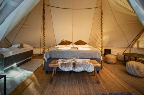 ein Schlafzimmer mit einem Bett in einem Zelt in der Unterkunft Gökaskratts Camping in Hovmantorp