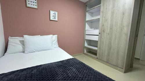 a small bedroom with a bed and a closet at CALI Acogedor y Completo, Apto cerca de Jardin plaza, con piscina, parqueadero y aire acondicionado in Cali