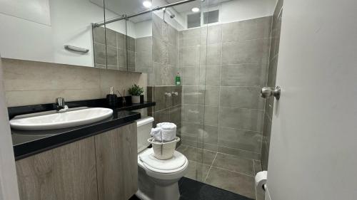 a bathroom with a toilet and a sink and a shower at CALI Acogedor y Completo, Apto cerca de Jardin plaza, con piscina, parqueadero y aire acondicionado in Cali