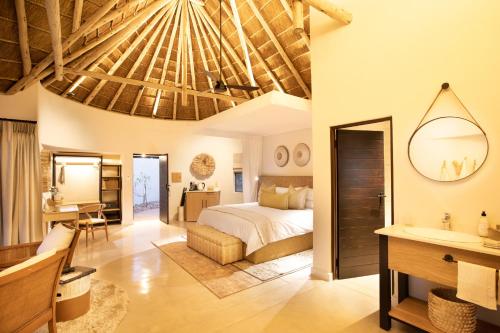 a bedroom in a villa with a bed and a desk at Serondella Game Lodge in Thornybush Game Reserve