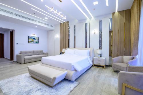 a white bedroom with a bed and a couch at Rumanza by Pearl Continental in Multan