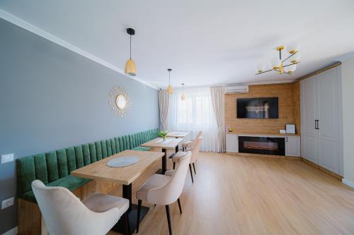 une salle à manger avec quatre tables et un canapé vert dans l'établissement Pensiunea Regal, à Baile Unu Mai