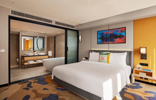 a bedroom with a large bed and a bath tub at Hyatt Centric Hebbal Bengaluru in Bengaluru