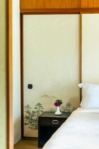 a bedroom with a bed and a vase with flowers on a table at Hokke Lumbini in Lumbini