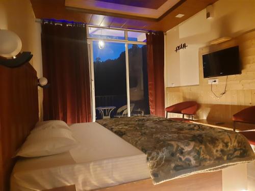 um quarto com uma cama e uma grande janela em Aagaman Woods Homestay em Shimla