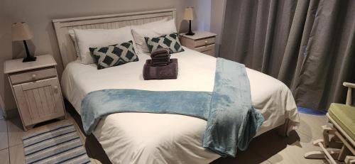 a bedroom with a bed with a blanket on it at Picollo Bocca Villa Kleinmond in Kleinmond
