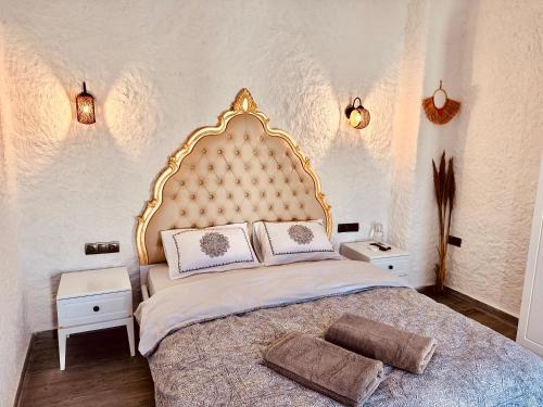 a bedroom with a large bed with a gold headboard at Paradise Hotel Alaçatı in Ildır
