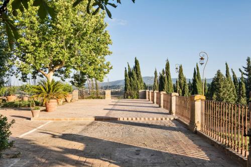 a brick walkway with a fence and trees at Tenuta di Megognano in Poggibonsi