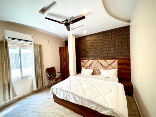 a bedroom with a large bed and a window at HOTEL VIA GANGA INN ! VARANASI ! FULLY AIR-CONDITIONED HOTEL AT PRIME LOCATION WITH ROOFTOP GANGES VIEW! 2 Min walking distance from ASSI GHAT ,NEAR KASHI VISHWANATH TEMPLE in Varanasi