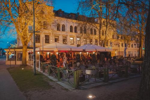 a group of people sitting at tables in front of a building at Stadshotellet Lidköping in Lidköping