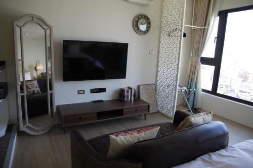 a living room with a couch and a flat screen tv at NK Hostel in Taipei