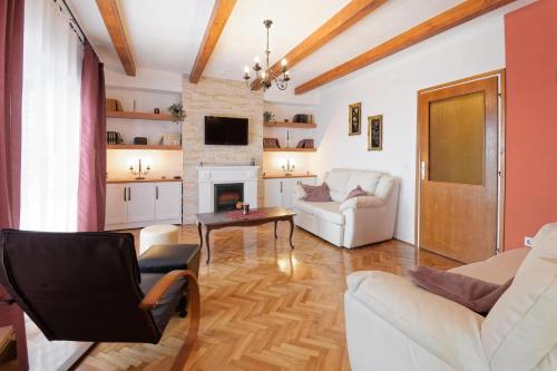 a living room with white furniture and a fireplace at Holiday Home Vlady in Buje
