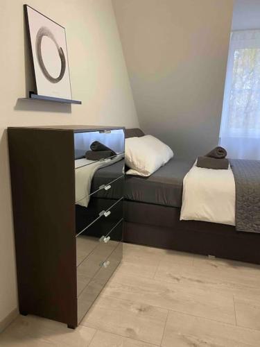 a bedroom with two beds and a dresser with a mirror at Modernes City Apartment Bayreuth in Bayreuth