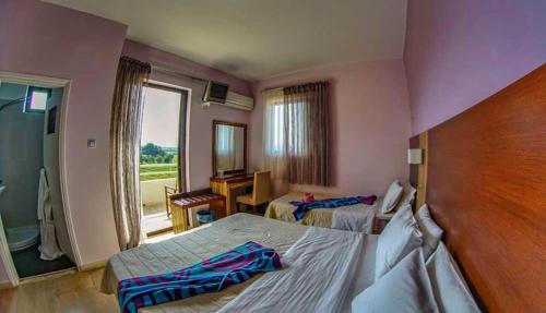 a hotel room with two beds and a window at GOLDEN SUN Κokkoni Beach Hotel in Vrahati