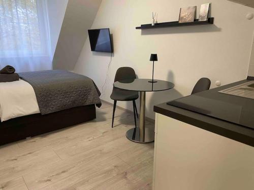 - une chambre avec un lit, un bureau et une table dans l'établissement Modernes City Apartment Bayreuth, à Bayreuth