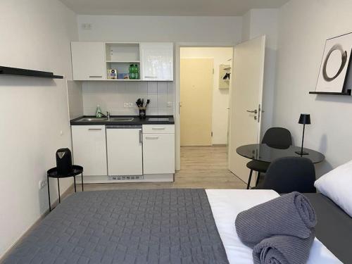 Cet appartement comprend une chambre avec un lit, une cuisine et une table. dans l'établissement Modernes City Apartment Bayreuth, à Bayreuth