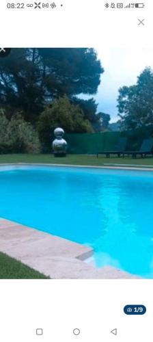 a blue swimming pool with a car in the background at Villa de charme avec piscine in Toulon