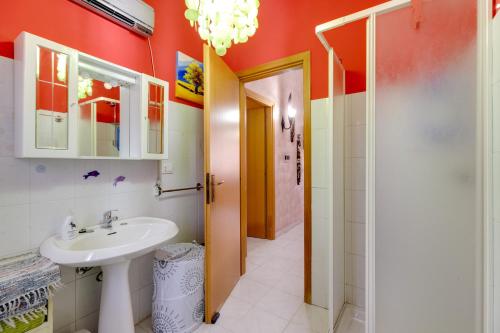 ein Bad mit einem Waschbecken und einem Spiegel in der Unterkunft Home Holidays Pintadera 1 in Bosa