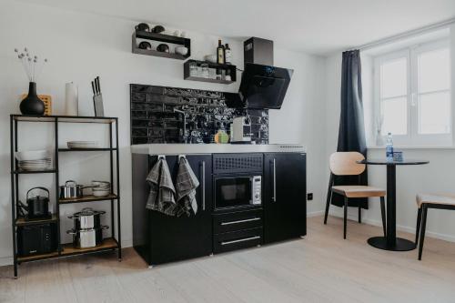 eine Küche mit einem Herd und einen TV in einem Zimmer in der Unterkunft sleepArt Black&White in Celle